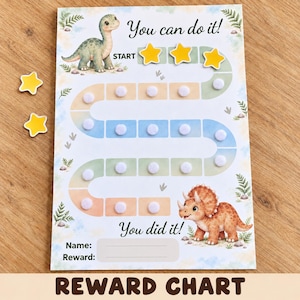 Peut inclure: Un tableau de récompenses illustré d'un dinosaure vert au départ et d'un tricératops à la fin. Le texte indique You can do it! et You did it! avec des espaces pour Name et Reward. Il comprend un chemin sinueux de carrés colorés avec des points velcro blancs et des étoiles jaunes.