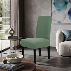 May include: A dining chair featuring a sage green textured waffle-knit fabric cover that fully encases the backrest and seat. The chair is supported by four straight, solid black wooden legs, providing a stable base for the upholstered seat.