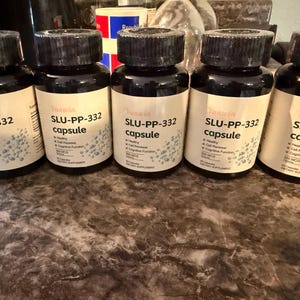 May include: Five identical dark brown plastic bottles with black screw-on caps, each featuring a white label. The labels display the text Yanwin, SLU-PP-332 capsule, and list benefits including healthy, cell renewal, and cognitive function.