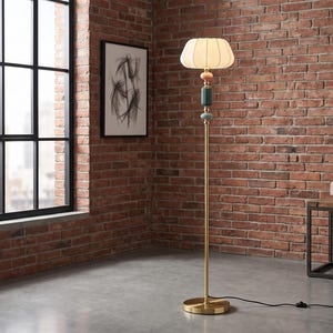 May include: A floor lamp with a thin gold metal pole and a round base. The lamp features a white pleated fabric shade and a decorative stem composed of a pink sphere, a ribbed dark green cylinder, and a light blue sphere below the light source.