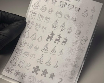 Peut inclure: Une planche d'autocollants pour ongles sur le thème de Noël, étiquetée Luxurya - Christmas Stickers. La planche présente diverses icônes de fêtes, notamment Mickey Mouse, Hello Kitty, Olaf, des rennes, le Père Noël, des bonshommes en pain d'épice, des flocons, des chaussettes et des sapins.