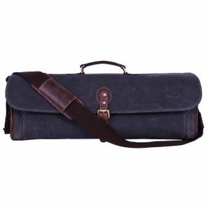 Könnte beinhalten: Eine dunkelmarineblaue rechteckige Tasche mit einem Tragegriff und einem braunen Schulterriemen. Die Tasche verfügt über eine Frontklappe, die mit einem braunen Lederriemen mit Metallschnalle gesichert ist. Der Text HLD LEATHER CO ist auf der Klappe eingeprägt.