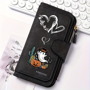 May include: A black wallet featuring a white graphic of two hearts and butterflies at the top, a small heart symbol in the center, and a colorful illustration of a ghost wearing a cowboy hat next to pumpkins and cacti, with the word FOREVER printed below.