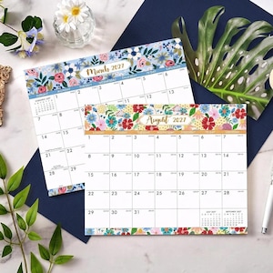 May include: Two paper calendar pages for March 2027 and August 2027. Each page features a grid layout with dates and a floral border at the top and bottom. The March page has a blue floral pattern, while the August page has a multi-colored floral design.