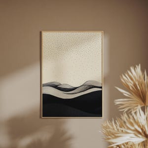 May include: A rectangular wall art print in a light wood frame featuring an abstract landscape. The upper section is a cream background with scattered black dots. The lower section displays layered, wavy lines in shades of gray and solid black.