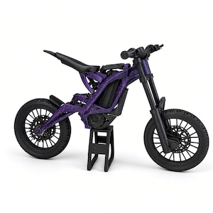 May include: A miniature electric dirt bike model featuring a purple speckled frame, black wheels with spokes, a black seat, and black handlebars. The bike is supported by a small black stand, showcasing a detailed suspension system and disc brakes.