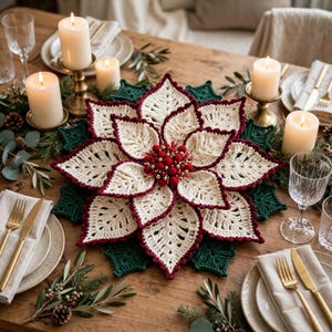 May include: A large, circular, crocheted poinsettia centerpiece featuring cream-colored petals with deep red scalloped edges, layered over dark green crocheted leaves, with a cluster of red and gold berries at the center.