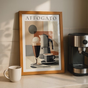 May include: A framed wall art print titled AFFOGATO featuring a geometric illustration of a moka pot, a glass with a scoop of ice cream, a coffee cup on a saucer, and a spoon, all rendered in shades of brown, beige, grey, and black.