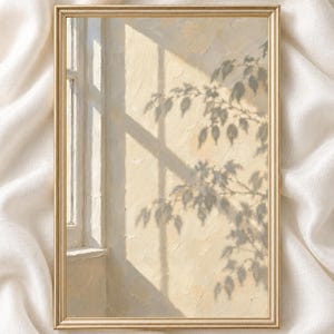 May include: A rectangular wall art print in a thin gold frame featuring an oil painting of a sunlit interior wall. The scene depicts a window casting sharp shadows of tree branches and leaves onto a textured, pale yellow wall surface.