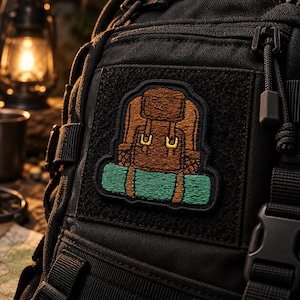 Puede incluir: Una mochila táctica negra con un parche bordado rectangular. El parche muestra una mochila de senderismo marrón con hebillas amarillas y un saco de dormir verde azulado sujeto en la parte inferior, todo con borde negro.