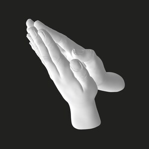 Puede incluir: Una escultura de color blanco mate que representa dos manos juntas en posición de oración. Las manos están hechas de un material blanco sólido y liso con detalles anatómicos realistas, incluyendo dedos, nudillos y uñas.