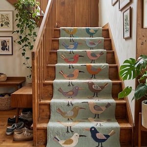 May include: A long, light green stair runner rug featuring a repeating pattern of various colorful birds in shades of blue, orange, red, yellow, and brown. The rug has a textured surface and is finished with white fringe at the bottom edge.