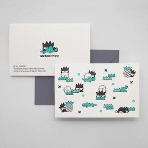 May include: White greeting cards with a repeating pattern of cartoon characters, pineapples, and crocodiles in black and teal. One card features the text "BAD BADTZ-MARU" and the Sanrio copyright information.