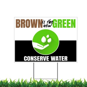 May include: A white sign with black and green accents. The sign reads "BROWN is the new GREEN" and "CONSERVE WATER". A green circle with a white hand and three water drops is in the center of the sign.