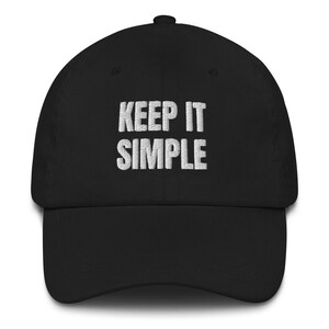 May include: A black baseball cap with white embroidered text that reads "KEEP IT SIMPLE".