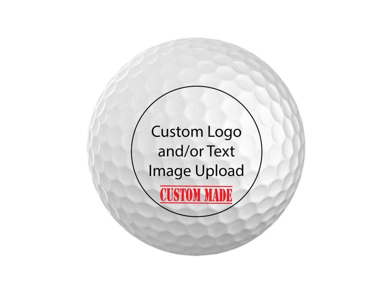 Puede incluir: Una bola de golf blanca con un c&iacute;rculo negro que contiene el texto "Custom Logo and/or Text Image Upload" y un sello rojo que dice "CUSTOM MADE".
