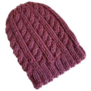 Puede incluir: Un gorro de punto burdeos con un patrón de trenza.