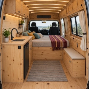 May include: The interior of a camper van featuring light-coloured wood panelling on the walls, ceiling, and floor. It includes a kitchenette with a sink and tap, a bed with pillows and a maroon throw blanket, a bench seat, and overhead storage cabinets.
