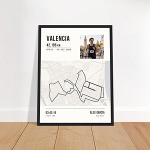 Könnte beinhalten: Ein gerahmtes Poster mit einer Karte der Marathonstrecke von Valencia, dem Text VALENCIA 42.195 KM SPAIN 06 DEC 2026, einem Foto eines Läufers, der Zielzeit 03:42:18, dem Namen ALEX GARCÍA und der Startnummer 18472 auf weißem Hintergrund.