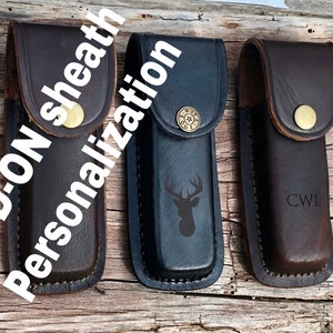May include: Three leather knife sheaths with different personalization options. The first sheath is plain brown leather. The second sheath is black leather with a deer silhouette. The third sheath is brown leather with the initials "CWL" engraved.
