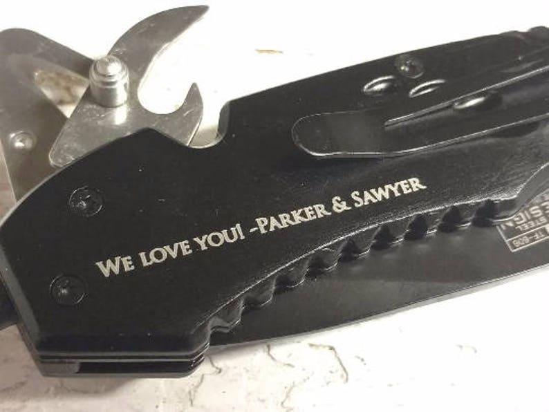 May include: Black multi-tool knife with a bottle opener, a blade, and a belt clip. The knife has an engraved message that reads "We love you! - Parker & Sawyer".