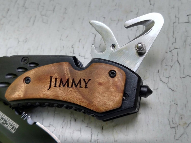 May include: A black multi-tool with a wood handle. The handle is engraved with the name "JIMMY".