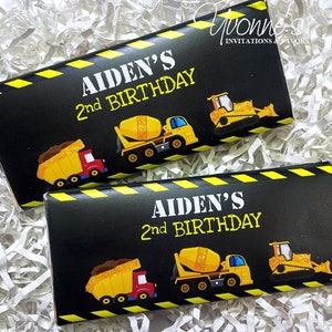 May include: Two black and yellow construction themed chocolate bar wrappers with the text "Aiden's 2nd Birthday" and images of construction vehicles.