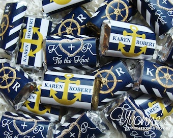 Puede incluir: Una colección de cajas de regalo a rayas azul marino y blancas con detalles dorados. Las cajas presentan temas náuticos, incluyendo anclas, timones y el texto "Tie the Knot".