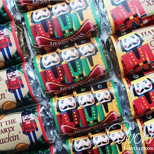 May include: A close-up of several small chocolate bars wrapped in festive foil with nutcracker designs and Christmas greetings. The wrappers feature red, green, gold, and white colors. The text on the wrappers includes "Get the party crackin'," "Merry Xmas," and "Have a Sweet Xmas."