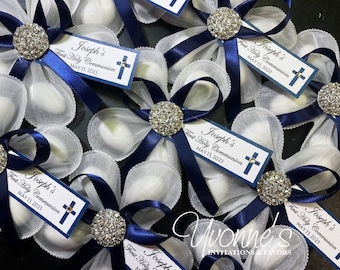 May include: White favor boxes with blue ribbon bows and a rhinestone embellishment. Each box has a tag that says "Joseph's First Holy Communion May 13, 2023" with a small cross.