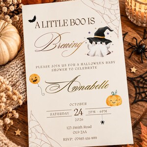 Può includere: Un invito rettangolare per baby shower a tema Halloween con il testo A LITTLE BOO IS Brewing, un fantasma con cappello da strega, un palloncino a forma di zucca, una zucca sorridente, ragnatele e il nome Annabelle con i dettagli dell'evento.