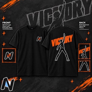 May include: A black short-sleeve t-shirt featuring a small letter N logo with an orange circle on the front. The back displays a large orange graphic of the word VICTORY and a white outline of a person pointing upward with one arm raised.