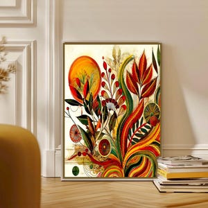 May include: A framed botanical art print featuring a vibrant, colorful floral design. The artwork showcases a mix of red, orange, yellow, and green hues, with a prominent sun-like shape and intricate plant details. The print is displayed on a wooden floor.