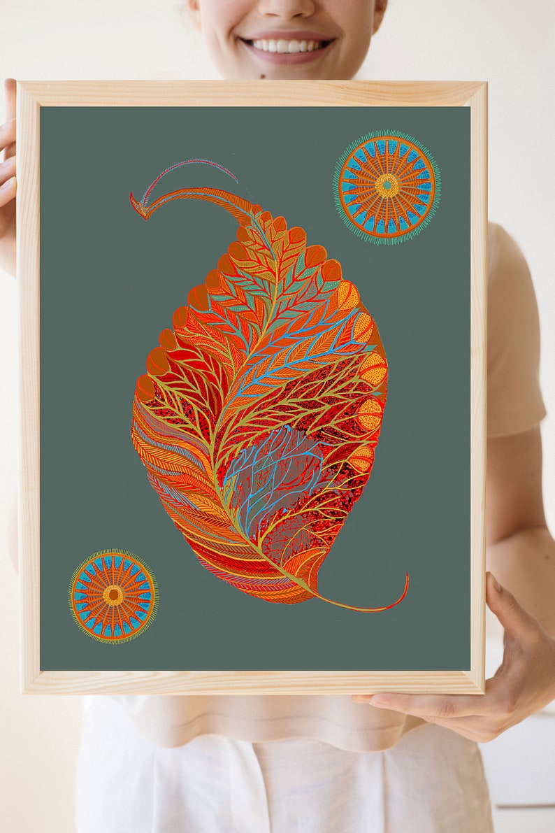 Puede incluir: Una impresi&oacute;n enmarcada con un dise&ntilde;o de hoja estilizado y abstracto en tonos de naranja, rojo y amarillo. La hoja est&aacute; rodeada por dos dise&ntilde;os circulares m&aacute;s peque&ntilde;os en tonos de naranja, azul y amarillo. El fondo es gris oscuro.