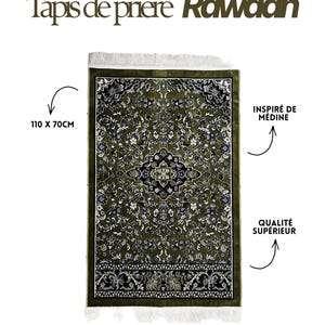 May include: A rectangular prayer rug measuring 110 x 70 cm, featuring an olive green background with intricate black and white floral patterns, a central geometric medallion, and white fringe on the top and bottom edges.