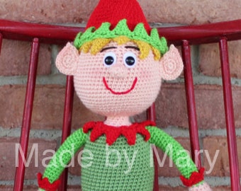 May include: A crocheted elf doll with a green and red outfit, white striped stockings, and a pointed hat with a yellow pom-pom.