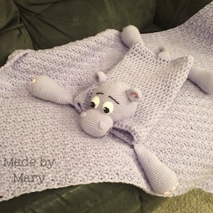 May include: A lavender crocheted baby blanket with a crocheted purple hippopotamus attached. The blanket has the text "Made by Mary" on it.