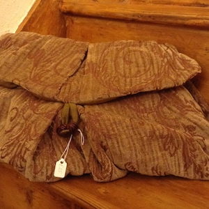 May include: A brown fabric pouch with a floral pattern and a green fabric tie. The pouch has a price tag attached to it.