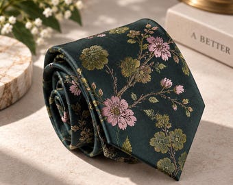 Può includere: Una cravatta verde scuro con un motivo floreale intrecciato di fiori e foglie rosa chiaro e verde oliva. Il tessuto ha una finitura liscia simile al raso e la cravatta è arrotolata a spirale, mostrando l'estremità a punta e il disegno floreale.