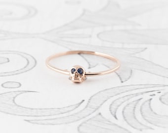 Anillo de calavera móvil de oro rosa de 14 quilates con ojos de zafiro