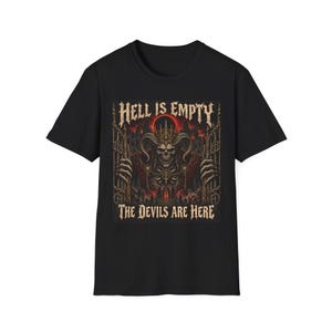 Może przedstawiać: Czarny t-shirt z krótkim rękawem z nadrukiem graficznym przedstawiającym rogatą postać szkieletu w koronie, stojącą za żelaznymi bramami. Tekst HELL IS EMPTY oraz THE DEVILS ARE HERE jest nadrukowany gotycką czcionką nad i pod grafiką.