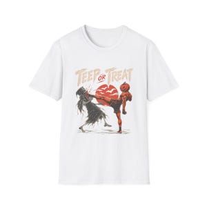 Puede incluir: Una camiseta blanca de manga corta con un estampado gráfico de una figura con cabeza de calabaza dando una patada a un esqueleto. El texto "TEEP OR TREAT" aparece sobre las figuras, sobre un fondo circular rojo con siluetas de murciélagos.