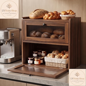 May include: A two-tier wooden bread box with a dark walnut finish and fluted glass doors. The top shelf holds loaves of bread, while the bottom shelf contains glass jars of preserves and a woven basket filled with assorted bread rolls.