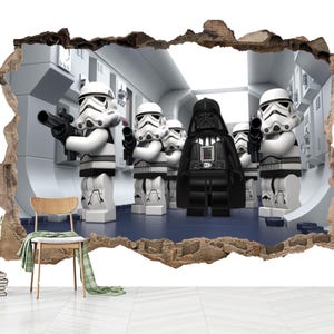 Pode incluir: Um adesivo de parede com efeito de buraco 3D que revela uma cena de Stormtroopers e Darth Vader estilo Lego em um corredor branco. Os personagens são brancos, pretos e cinzas, segurando blasters sobre um piso azul escuro.