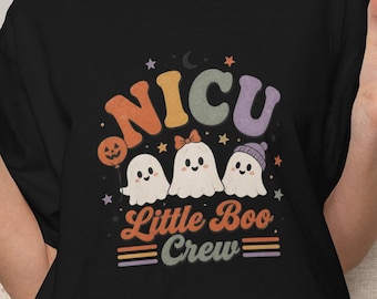 May include: A black t-shirt featuring a graphic with the text NICU Little Boo Crew in colorful retro-style lettering. The design includes three white ghost illustrations, one holding a pumpkin balloon, with small stars and a crescent moon.