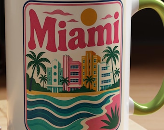 May include: A white ceramic mug with a light green interior and handle. The front features a colorful graphic of Miami with palm trees, art deco buildings, a yellow sun, and stylized ocean waves. The text Miami is printed in large pink letters.