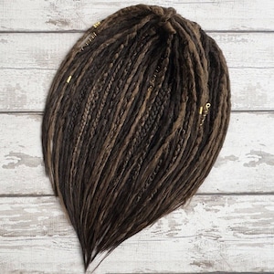 Side angle view of brown mix double ended dreadlocks laid flat. High-quality synthetic Kanekalon hair, lightweight and reusable. Available in custom length and single or double ended formats. Festival hair accessory, great for rave, cosplay, or Burning Man.