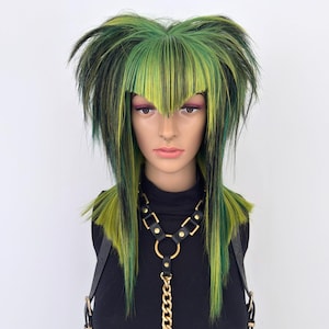 May include: A mannequin head with a green and black wig and a black leather harness with gold-coloured chain and rings. The wig has a blunt fringe and long, layered strands. The mannequin is wearing a black turtleneck.