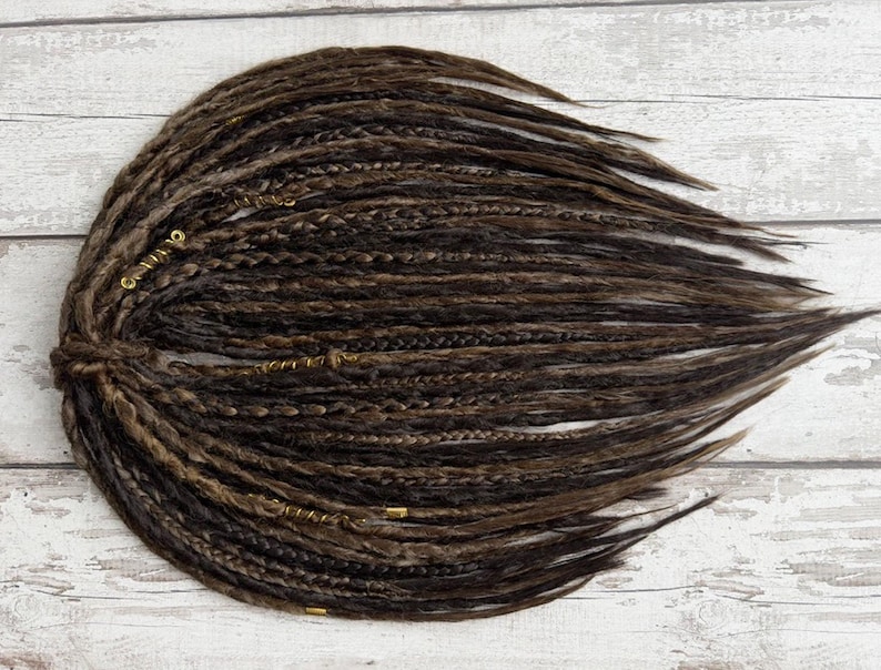 Premium-quality crochet dreadlocks in brown tones, displayed in a neatly arranged bundle. These synthetic loc extensions mimic the natural dreadlocked appearance with detailed braiding and hand-wrapped elements. Available in multiple sizes, perfect for achieving a full-head dread look or adding accent pieces.