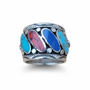 May include: A silver ring featuring four inlaid, oval-shaped stones in turquoise, coral, blue, and turquoise. The ring has a wide band with decorative detailing around the stones and along the edges, showcasing a Southwestern design.